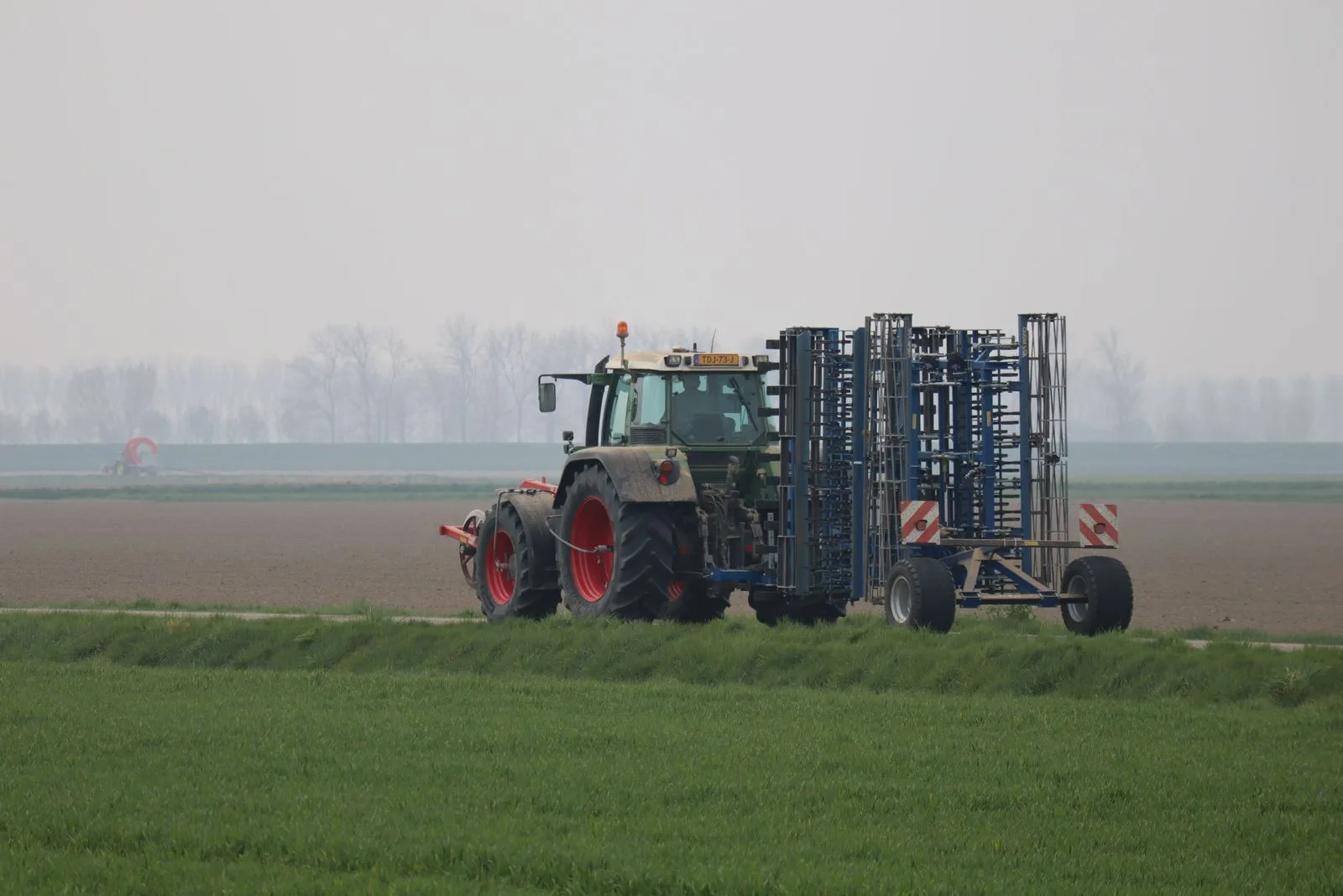 Tractor pulling an implement across a cultivated field