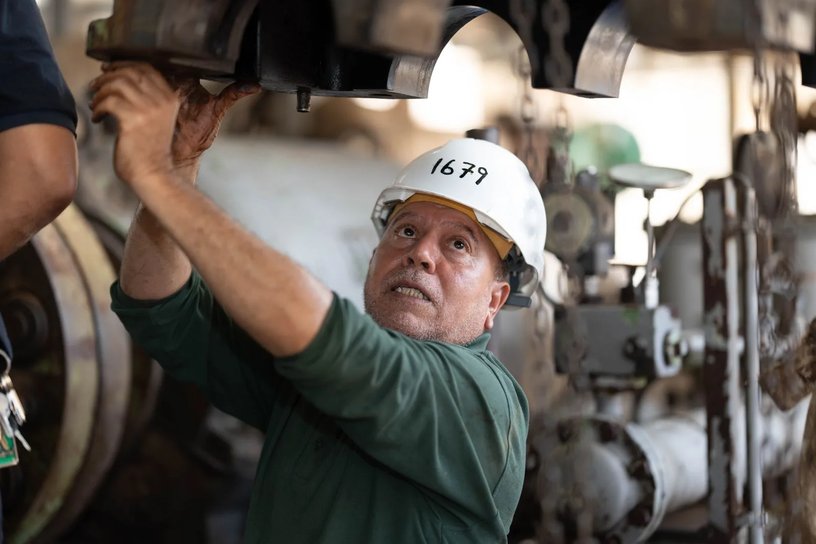 Maintenance technician working on industrial equipment with a tablet