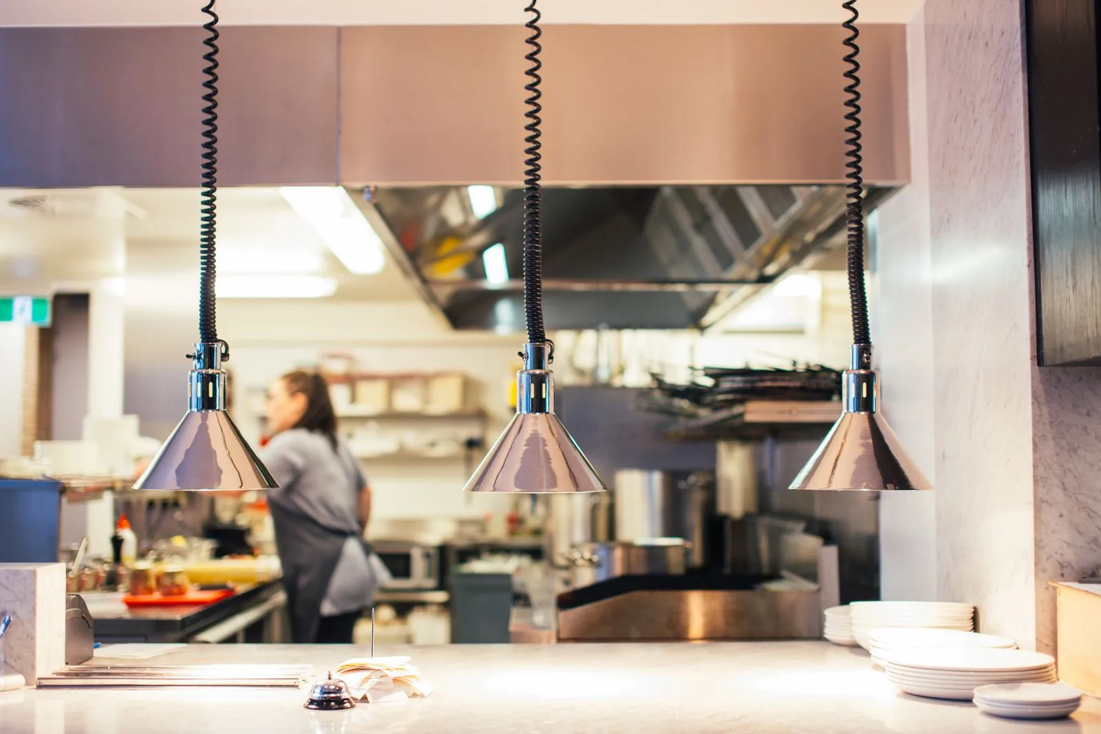 Commercial restaurant kitchen with stainless steel equipment and heat lamps